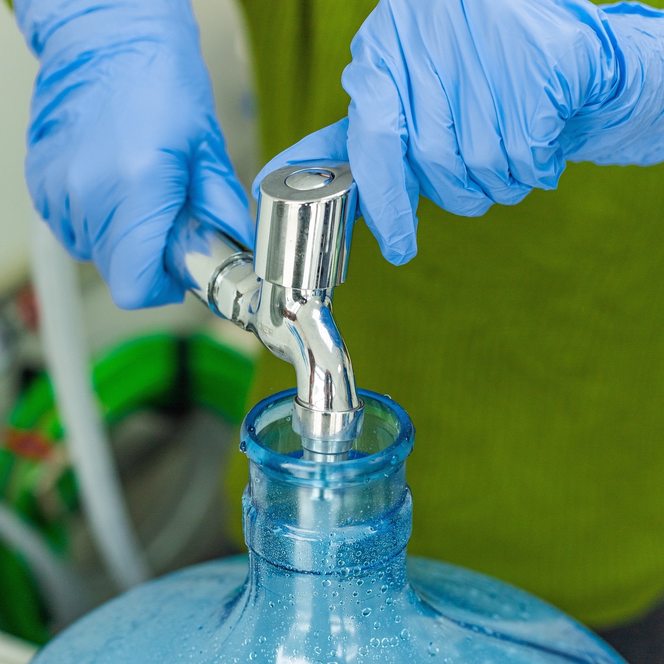 Gloved personnel gathering water