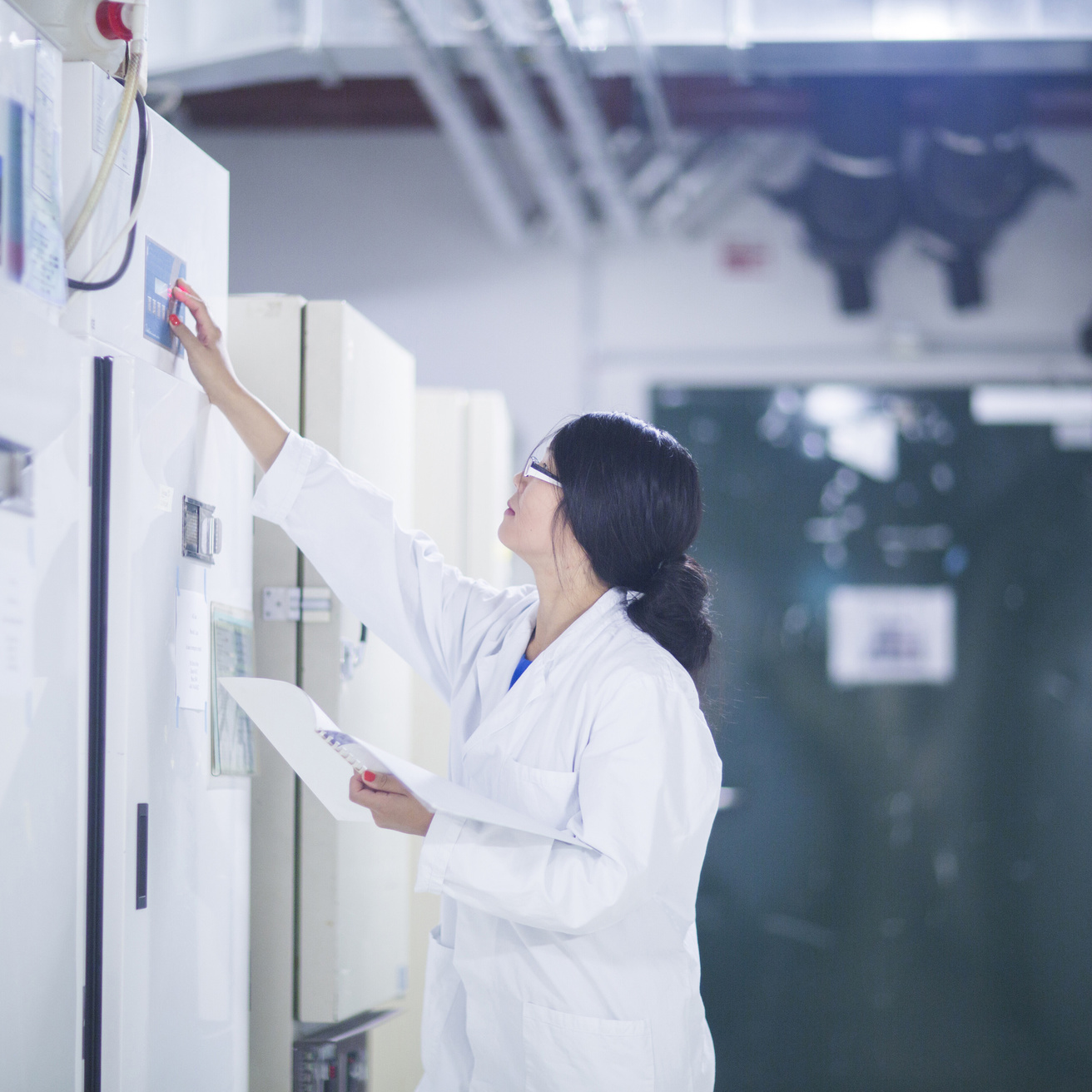 Scientist setting temperatures in an ultra-low temperature freezer bay