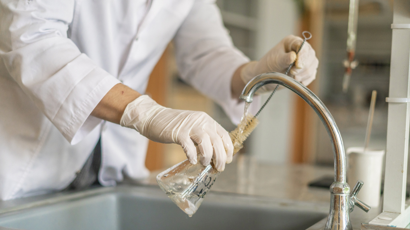 Scientist washing beaker